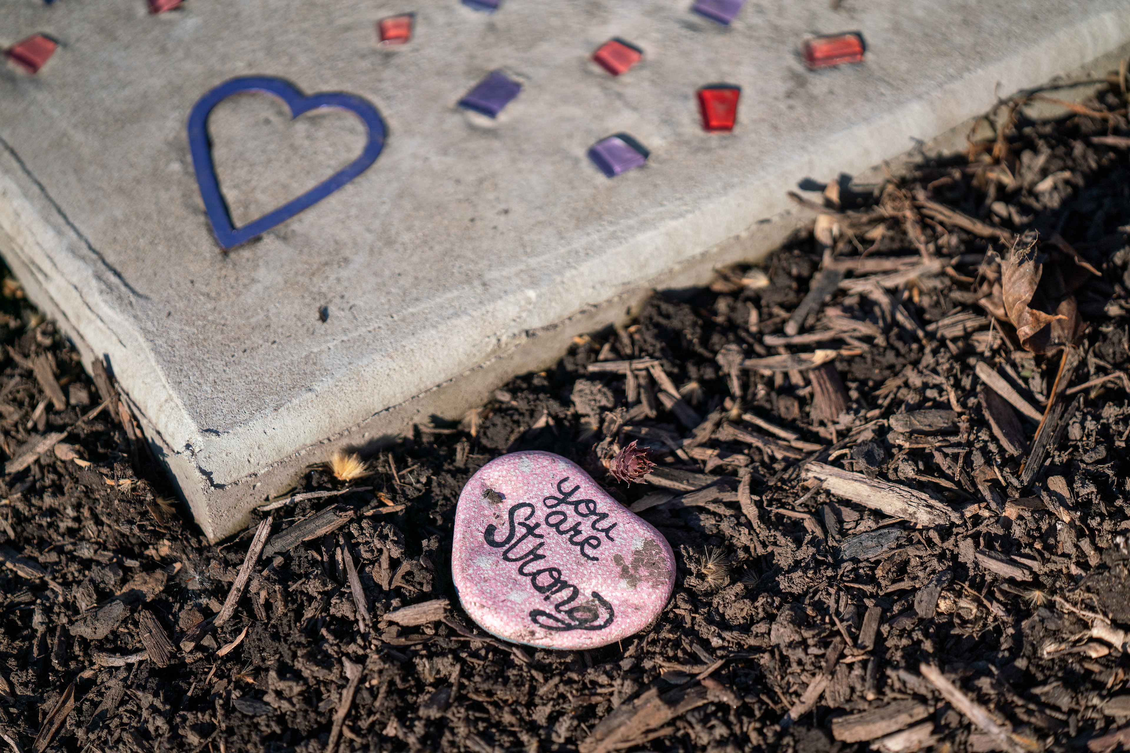 A stone that is painted with the phrase "You are strong" sits on the ground at the Circle of Hope statue in Tuckahoe Park in Altoona, Pennsylvania.